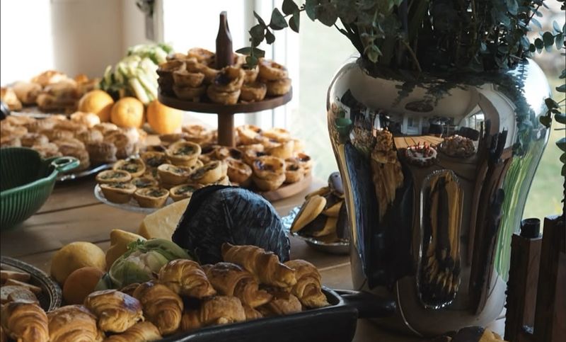 Mesa de festa com pastéis de nata, croissants e fruta